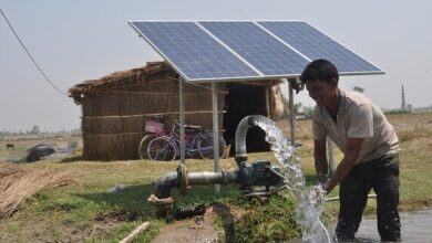 Indian villager using solar panels for water extraction, exemplifying the realization of the Sustainable Development Goals SDGs by 2030 to empower local governments and communities.
