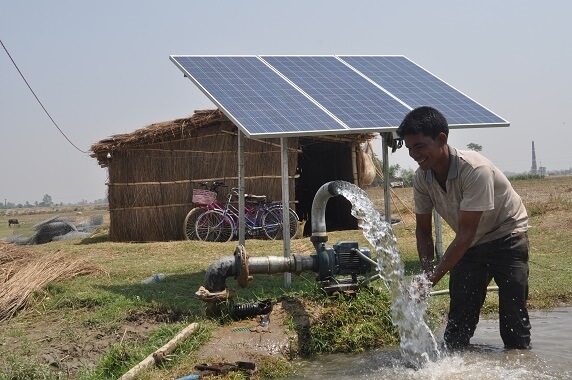 Indian villager using solar panels for water extraction, exemplifying the realization of the Sustainable Development Goals SDGs by 2030 to empower local governments and communities.
