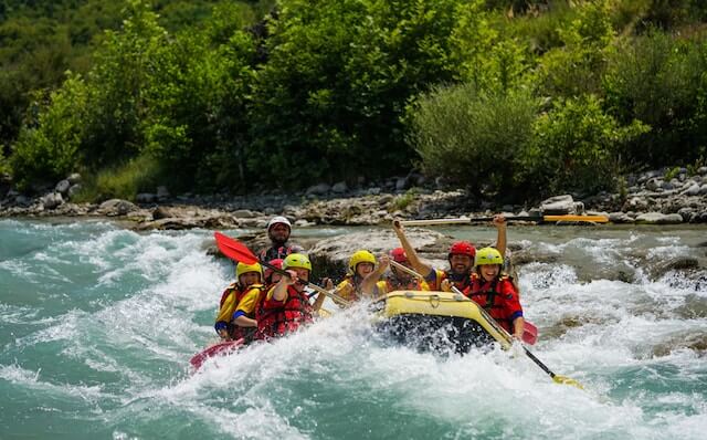 Competitors riding on kayak on a angry river, symbolizing the collective effort and urgency in achieving the UN 2030 SDG Goals through a science-driven framework of the SDGs.